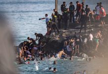 Gutt flyktet til Spania gjemt under fotballbuss Tusenvis forsøkte å ta seg over grensen fra Marokko til den spanske eksklaven Ceuta i slutten av juli. Foto: Antonio Sempere / AP / NTB